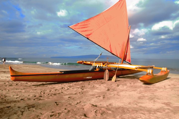a boat sitting on top of a sandy beach