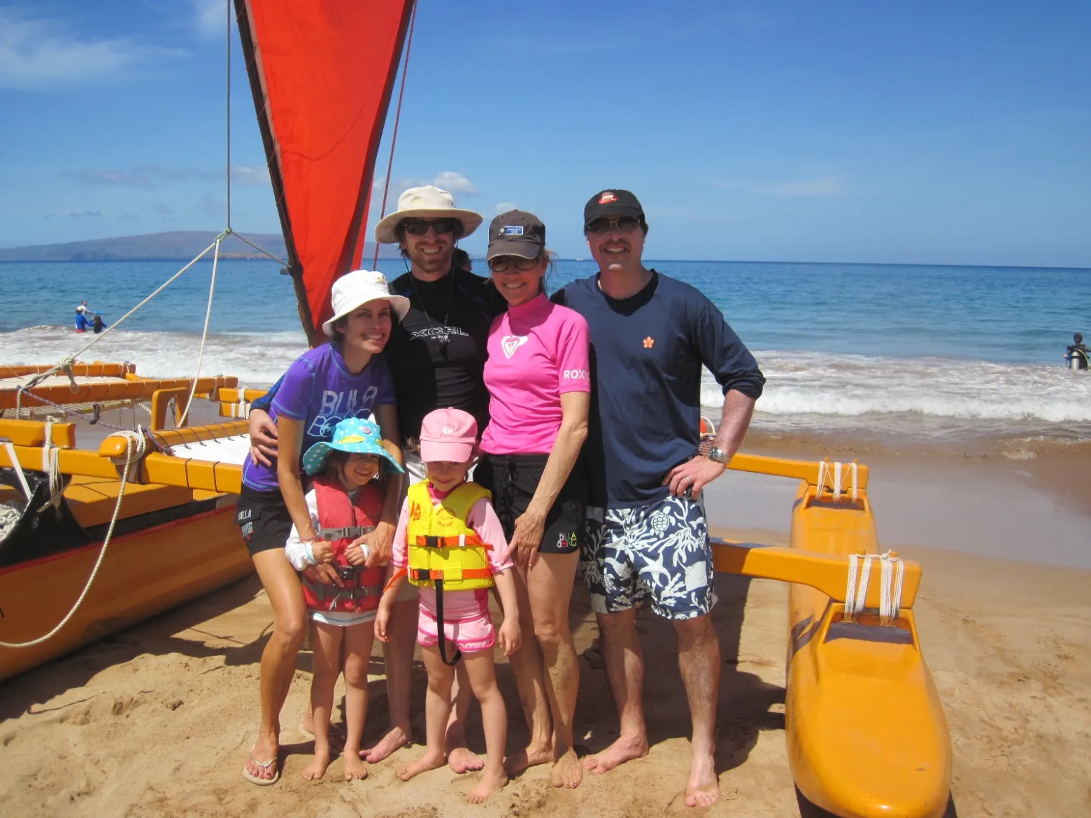 a group of people standing on top of a sandy beach