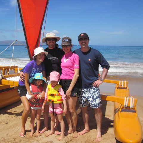 a group of people standing on top of a sandy beach