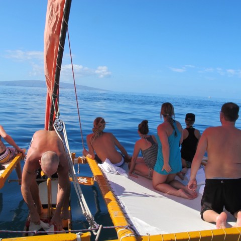 a group of people standing next to a body of water