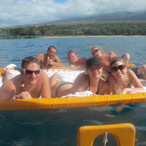 a group of people sitting on a raft in a body of water